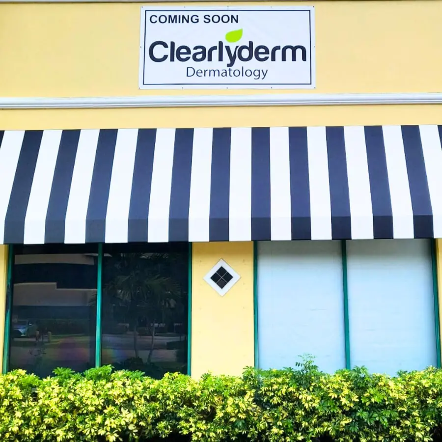 Coming soon banner over a striped awning