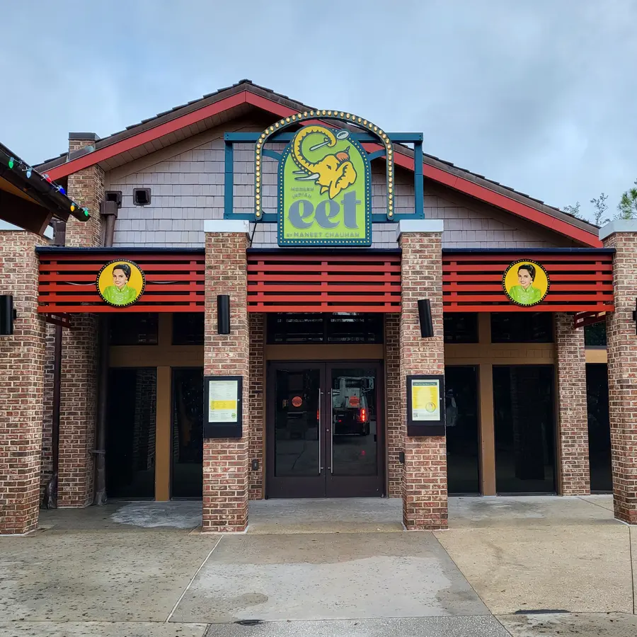 Eet restaurant facade with custom illuminated marquee logo sign and round medallion signs