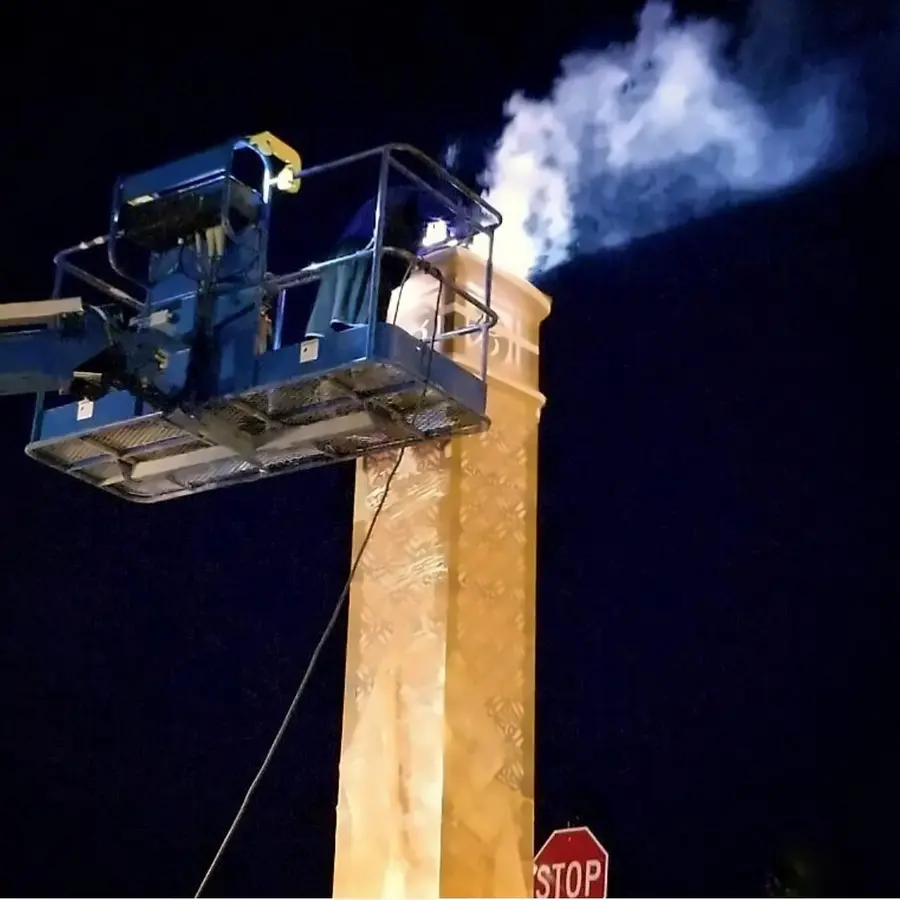 Night sign installation from a bucket truck, with welding sparks